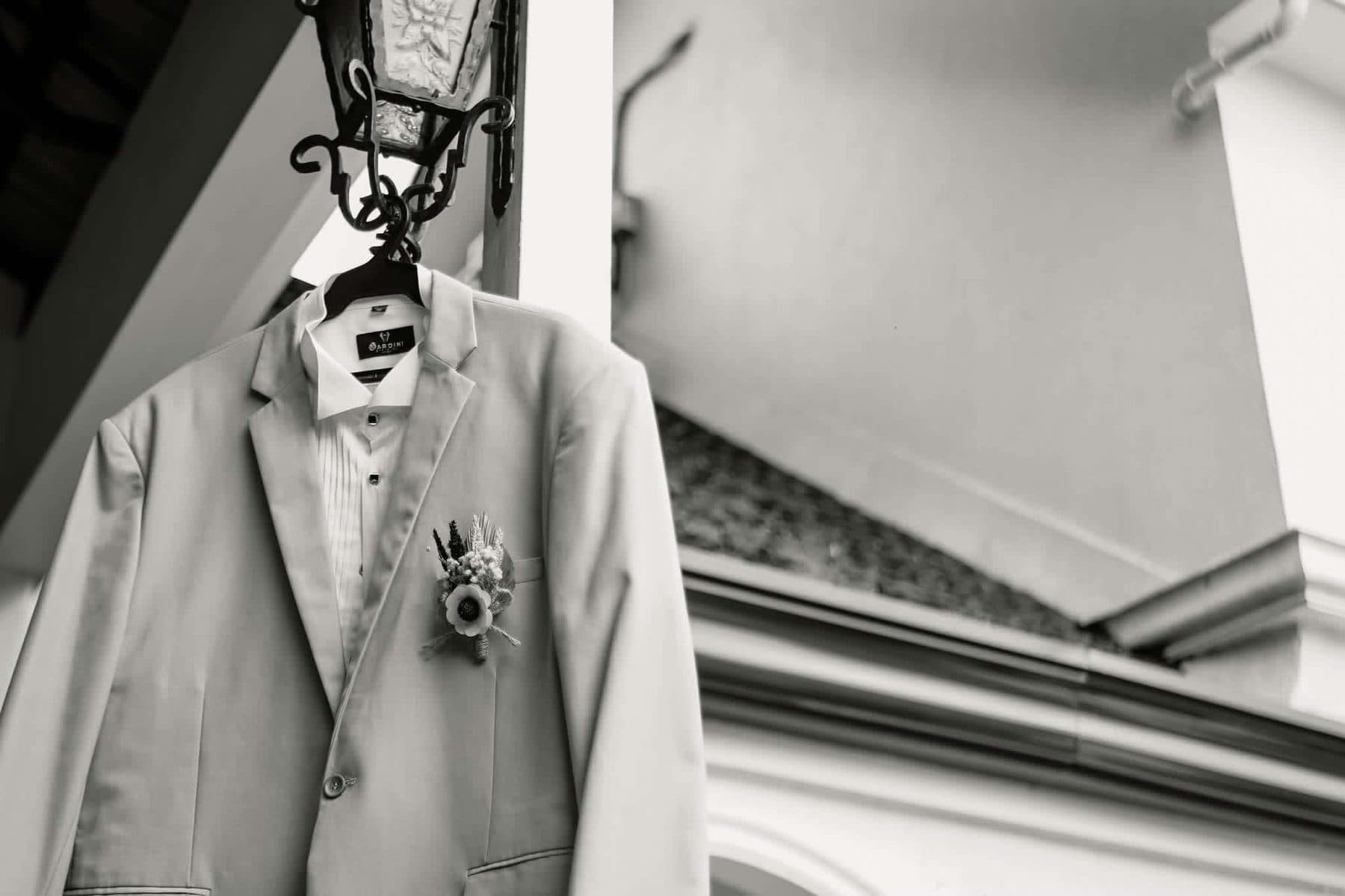 Groom's suit with a boutonniere hanging under a lantern